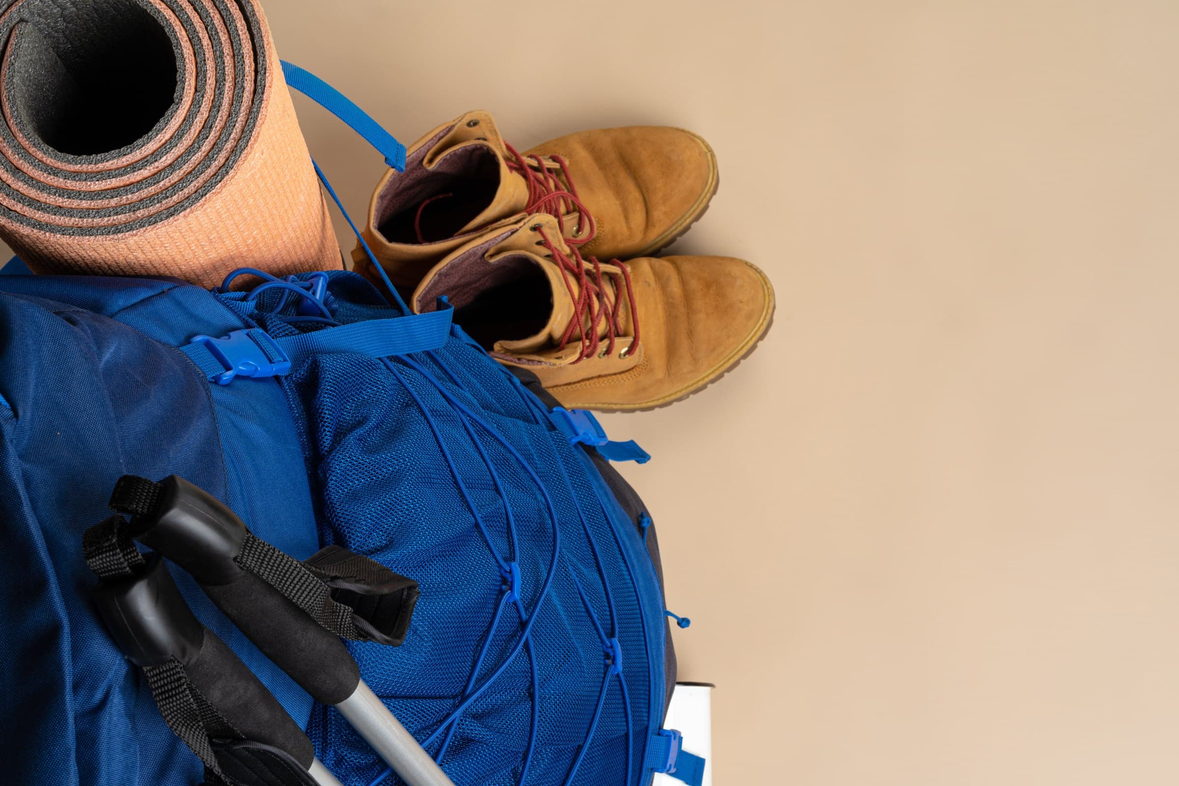 Trekkingrucksack mit Wanderstiefeln und Wanderstöcken für die Kilimandscharo-Besteigung — die richtige Packliste entscheidet über Erfolg oder Scheitern