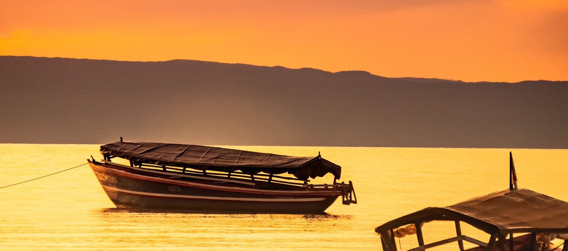 Traditionelle Boote vor der Küste Sansibars bei Sonnenuntergang