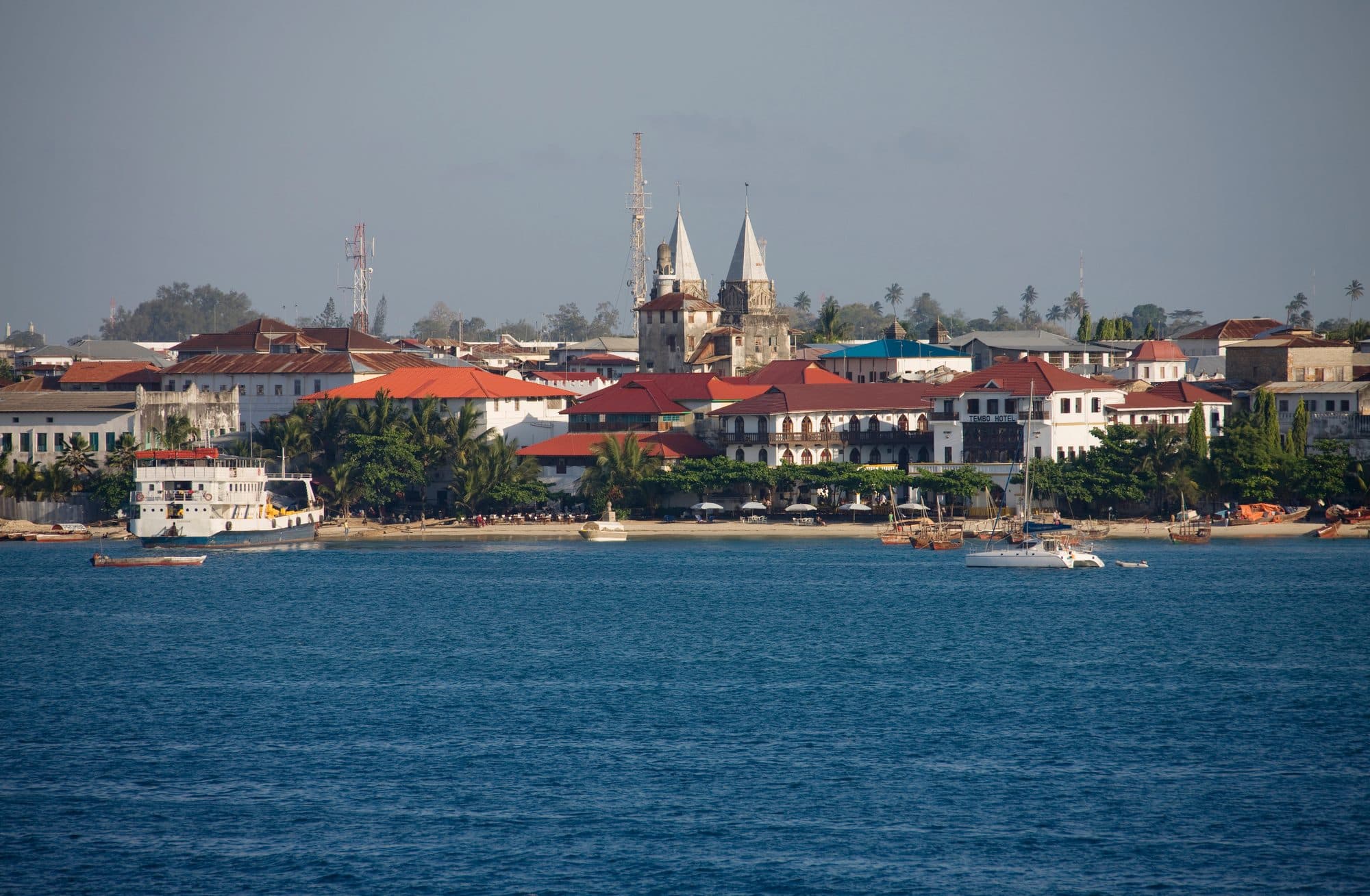 Blick vom Wasser auf Stone Town, Sansibar, mit Booten vor der historischen Altstadt