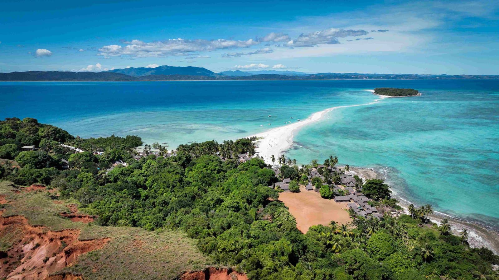Rote Steilküste und dichter Regenwald an einem Strandabschnitt in Madagaskar