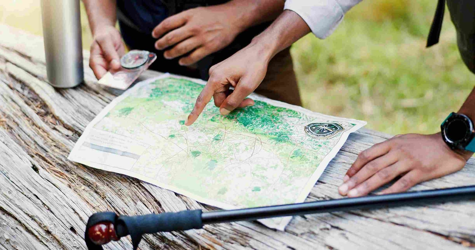 Reisende planen mit Karte und Kompass eine Route für ihre Madagaskar-Reise