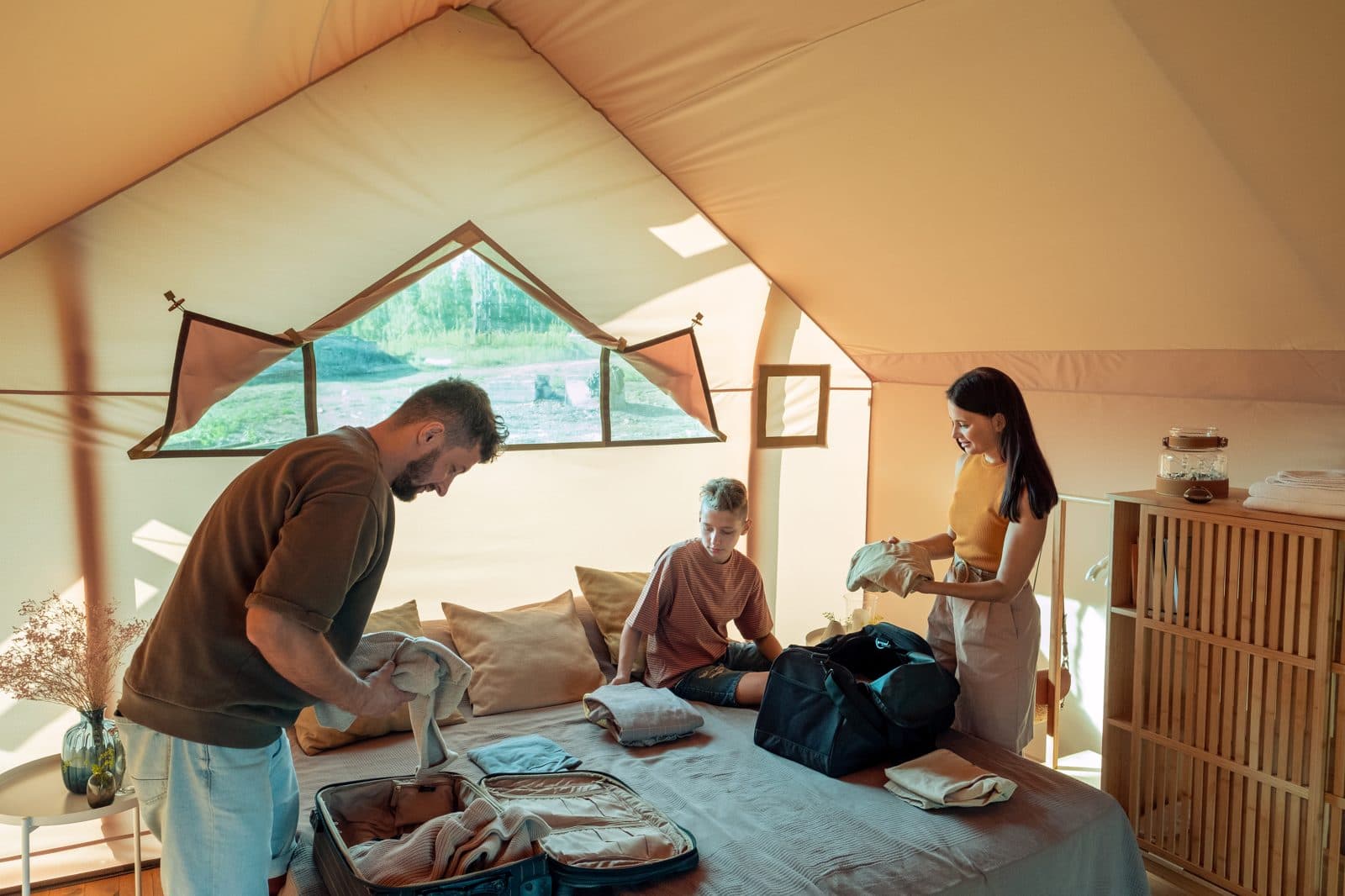 Familie packt gemeinsam Koffer und Reisetasche für die Safari