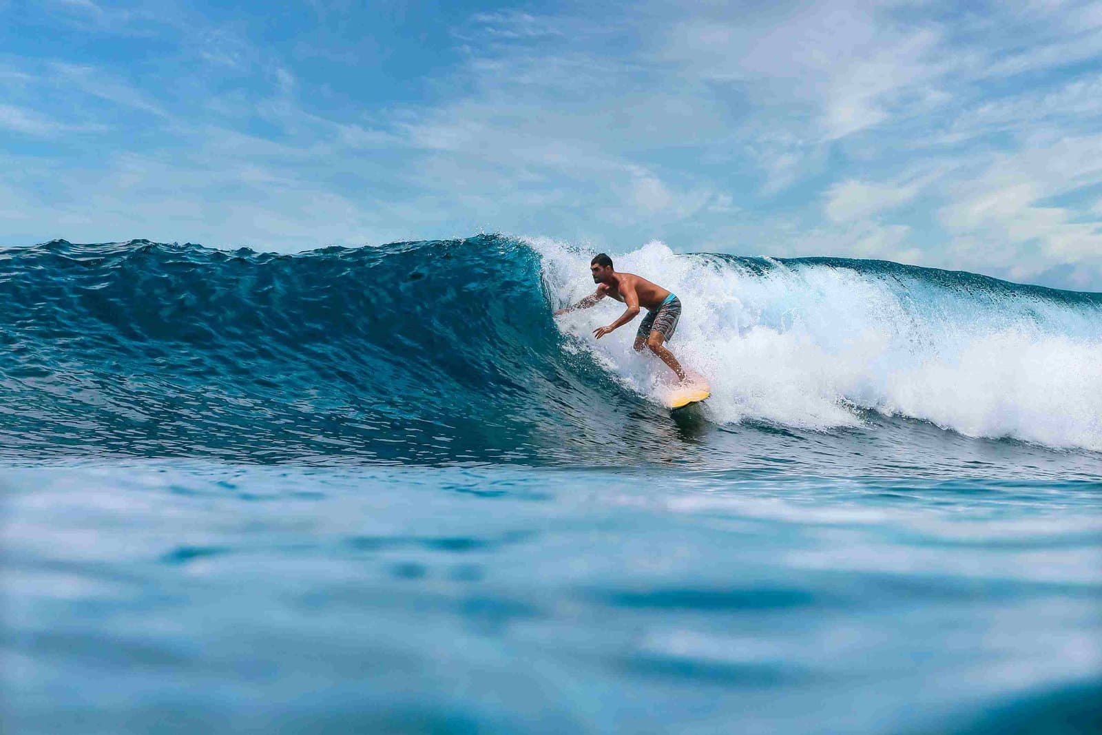 Surfer fährt eine Welle vor der Küste Sansibars