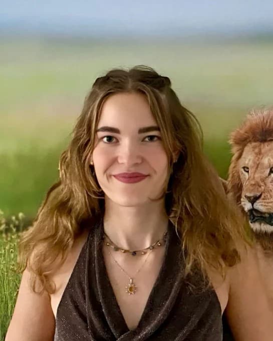 Susanne Stefaniack vom Team Tansania Reiseabenteuer vor einem Löwen-Wandbild