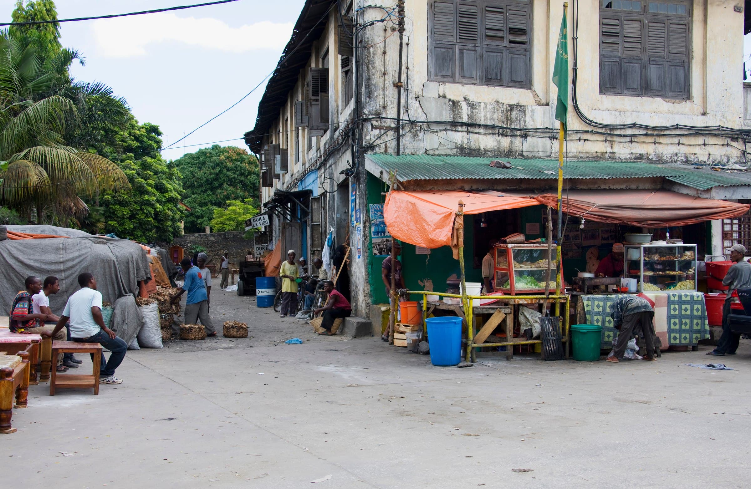 Historische Gasse in Stone Town, Sansibar, mit traditioneller Swahili-Architektur und Straßenleben — die Gewürzinsel zählt zu den schönsten Reisezielen Ostafrikas