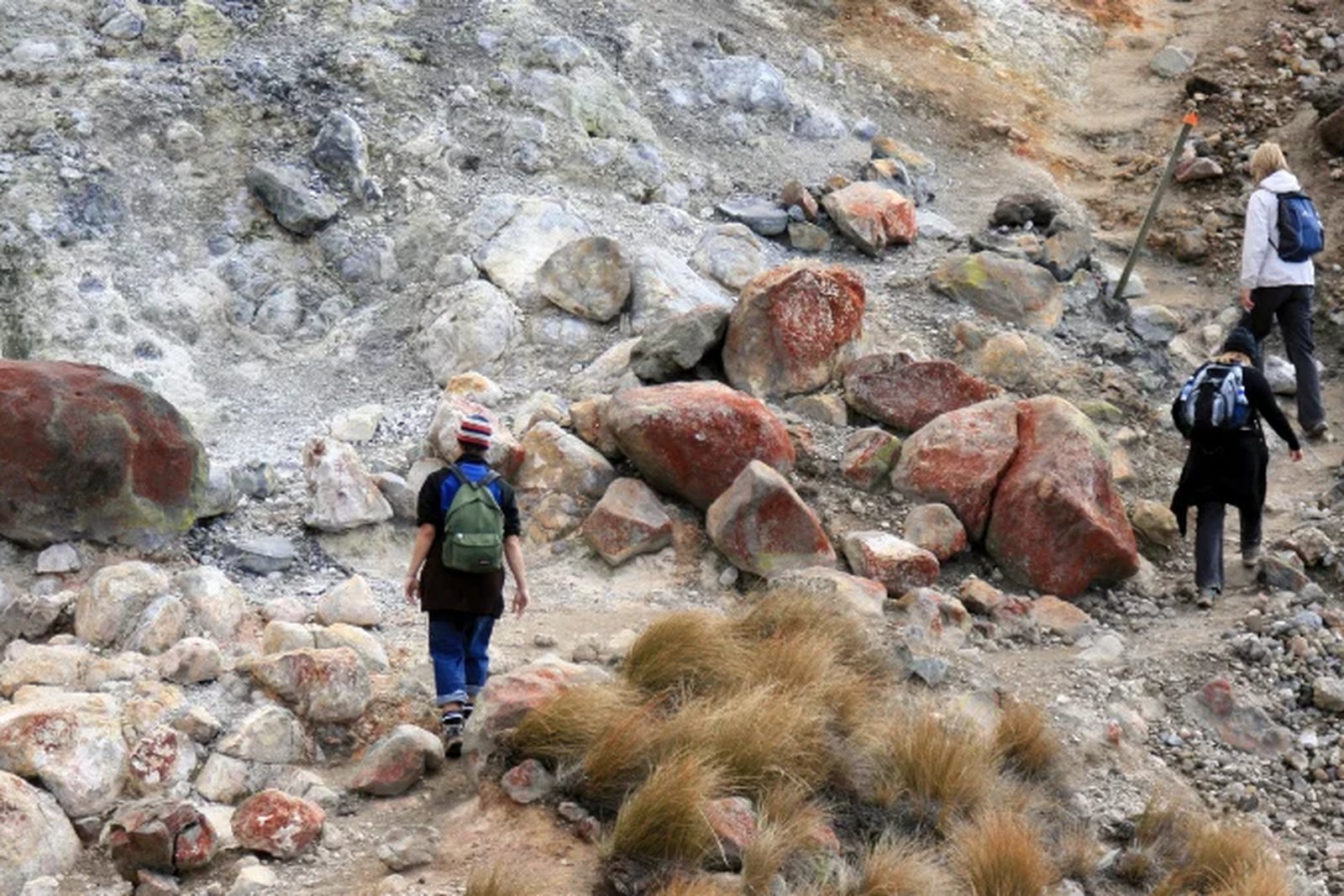 Trekker im Hochgebirgsbereich des Kilimandscharo auf dem Weg zum Gipfel – steile Felsen und Wolken