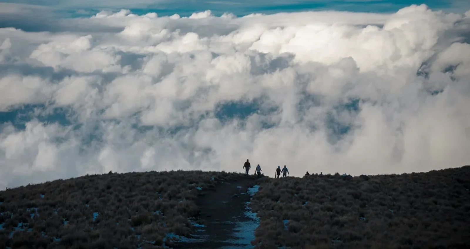 Trekker-Silhouetten über dem Wolkenmeer – die einsamste Route am Kilimandscharo in der Gipfelzone