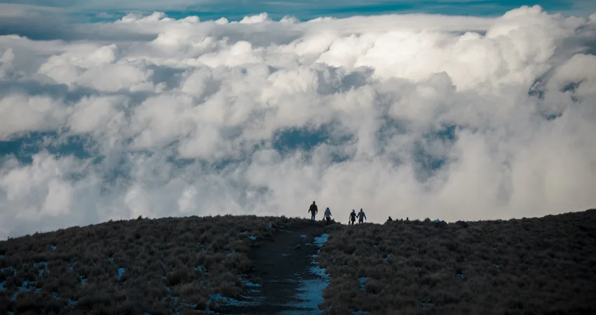 Trekker-Silhouetten über dem Wolkenmeer – die einsamste Route am Kilimandscharo in der Gipfelzone